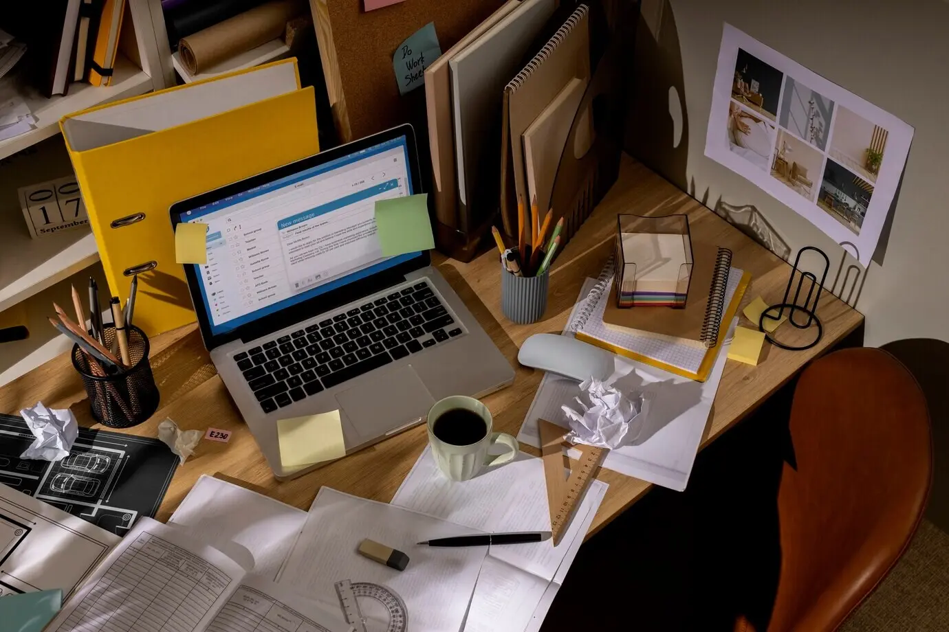 A view of an office desk with a cluttered workspace and a laptop.